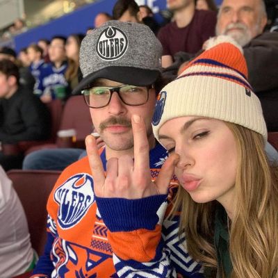 Both are wearing Edmonton Oilers jersey and taking a selfie with Jesse throwing rock sign.